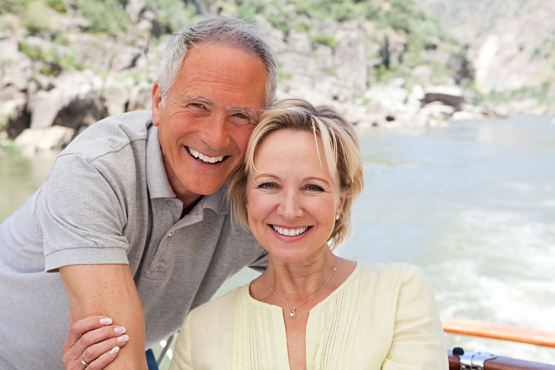 Smiling mature couple outdoors representing restored confidence after missing teeth treatment
