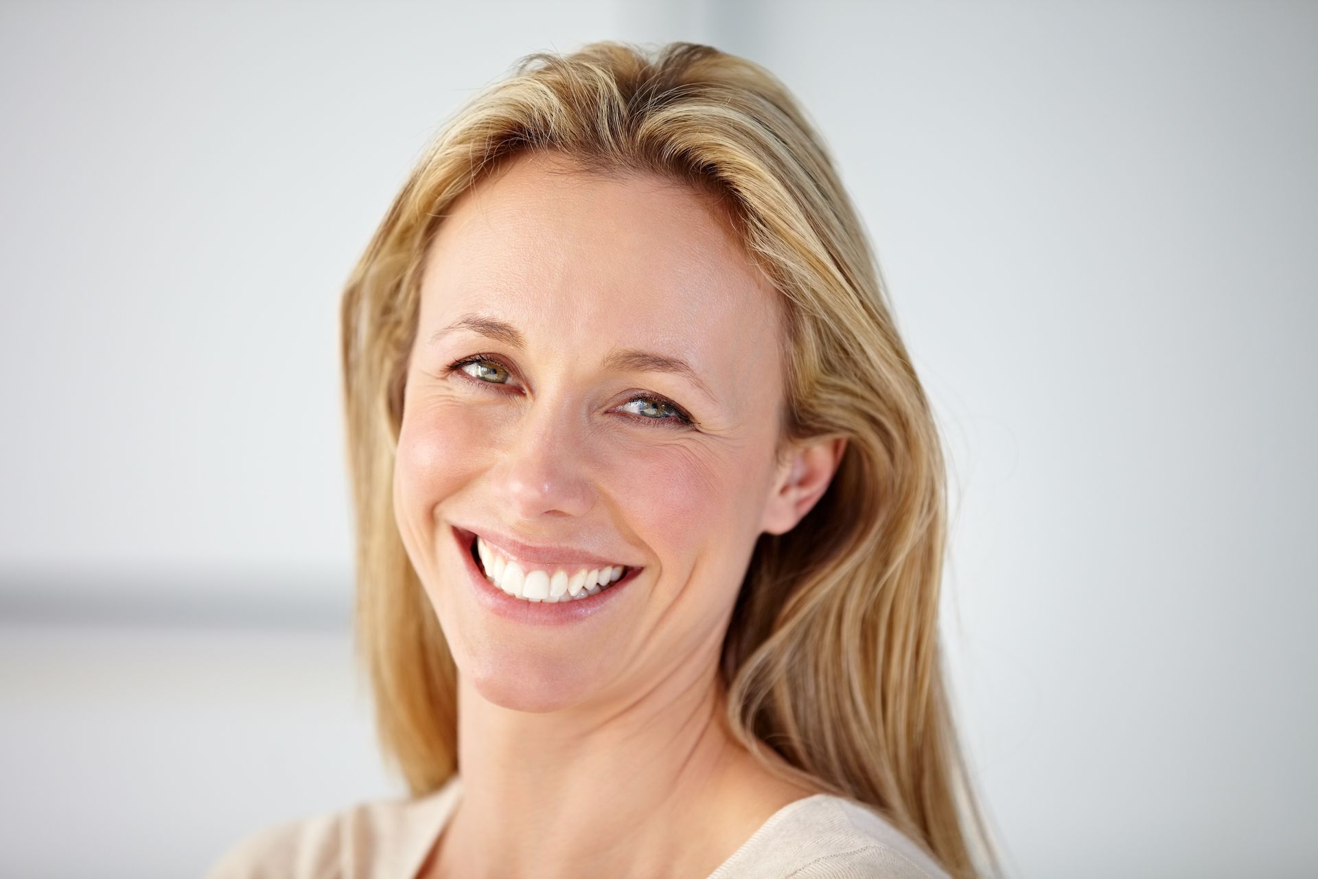 white blonde woman smiling with a perfect smile