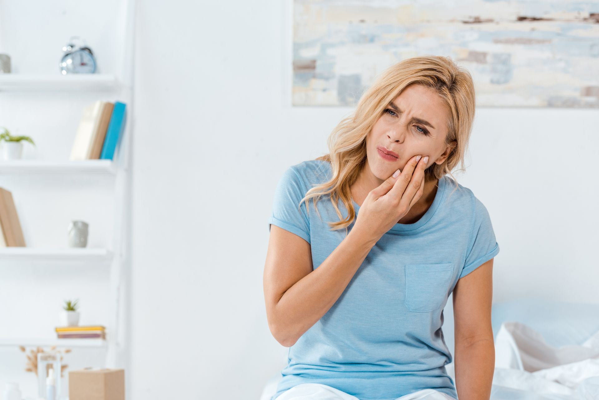 upset woman touching cheek while having toothache dental emergency