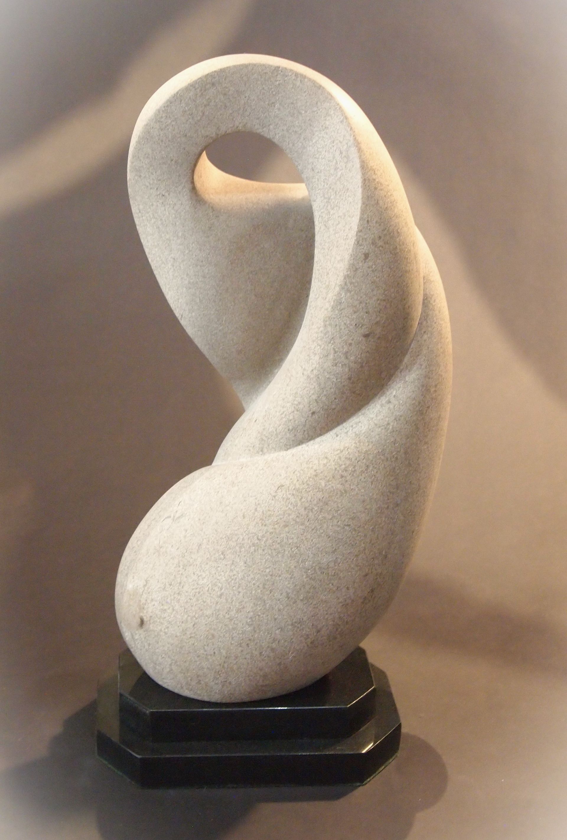 A sculpture of a swirl on a black base