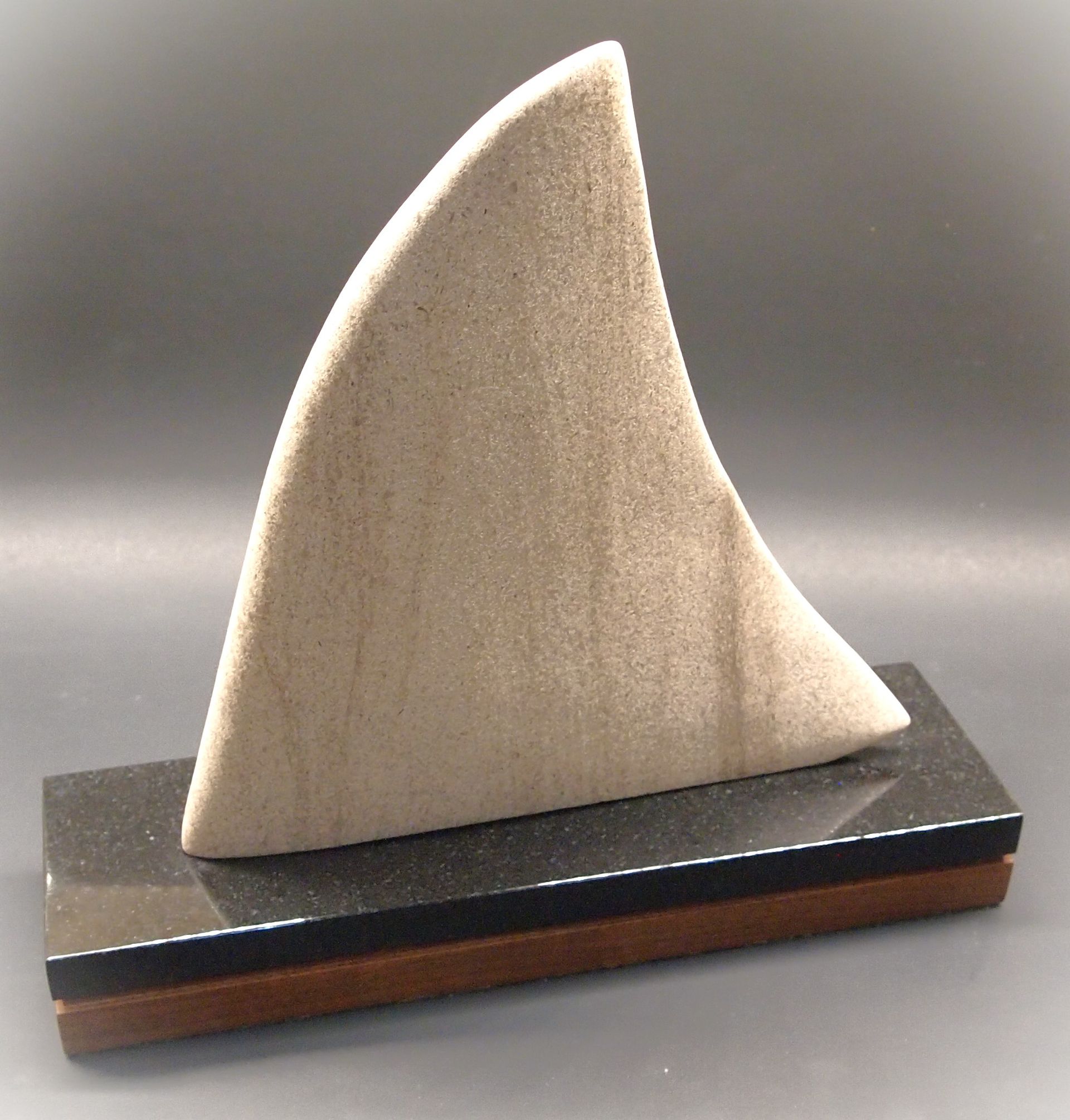 A sculpture of a sailboat on a black base