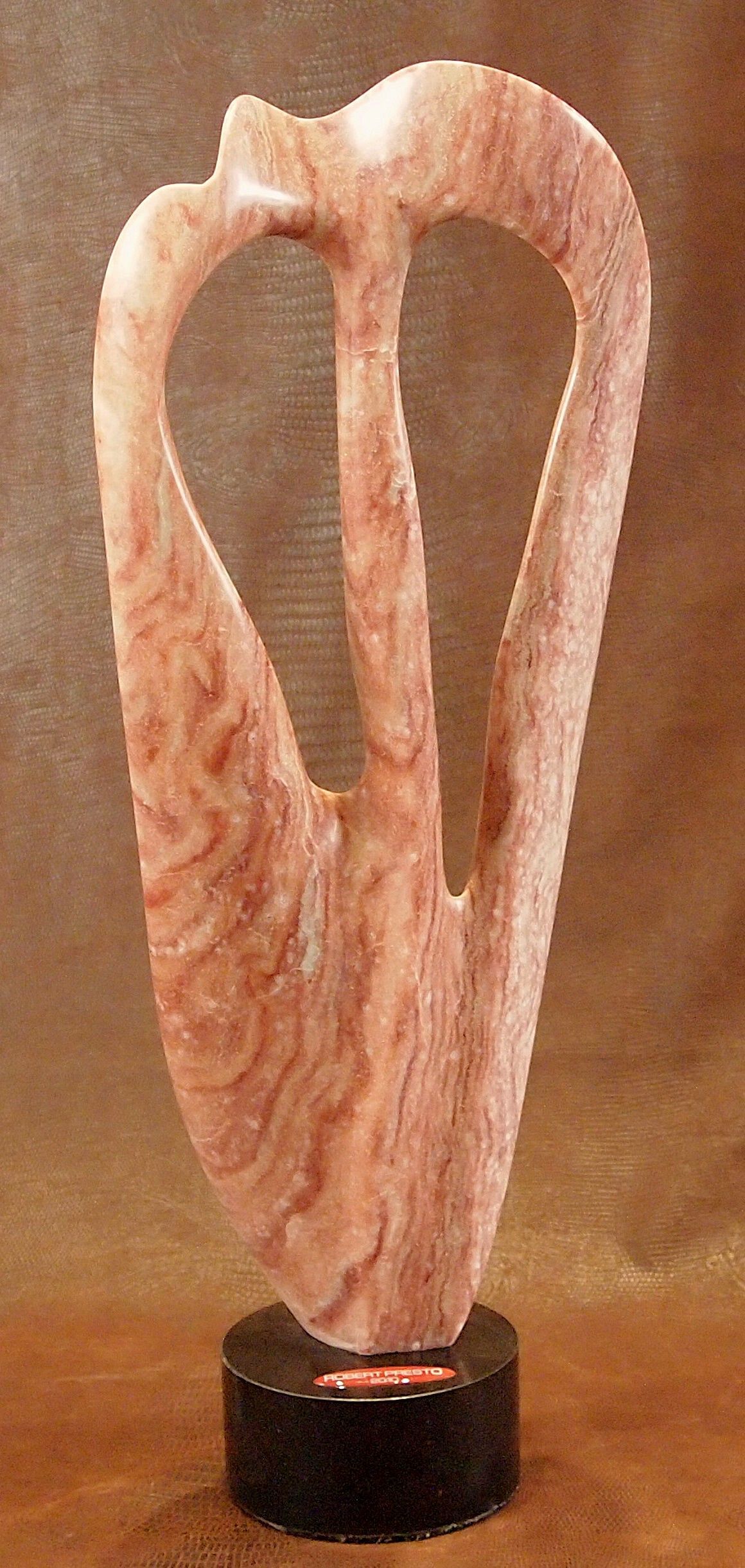 A sculpture of a heart is sitting on a wooden table.