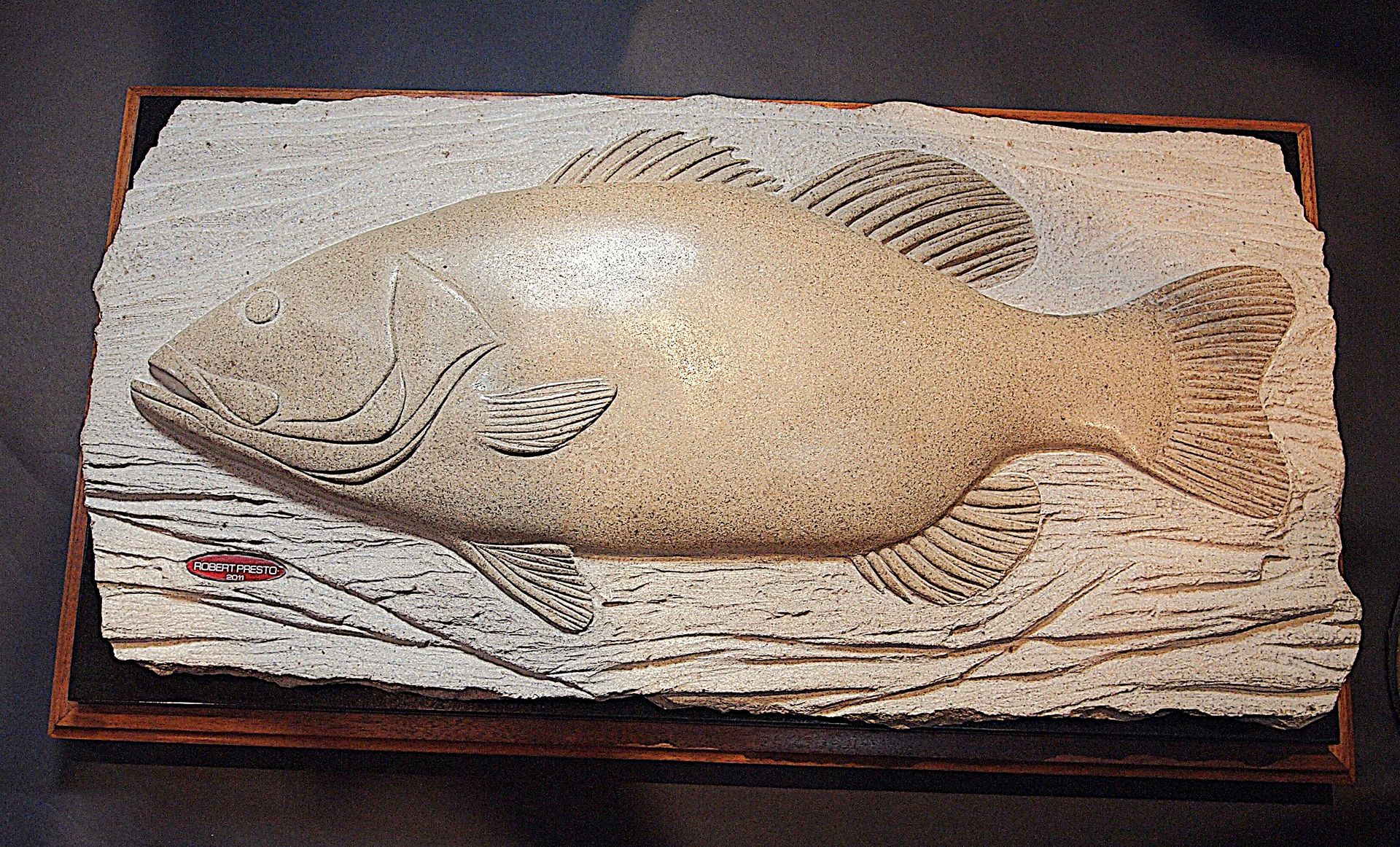 A large fish is carved into a piece of wood