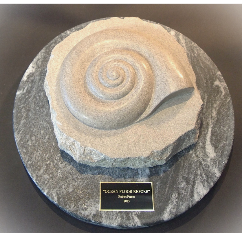 A sculpture of a sea shell on a marble plaque that says ocean floor reserve