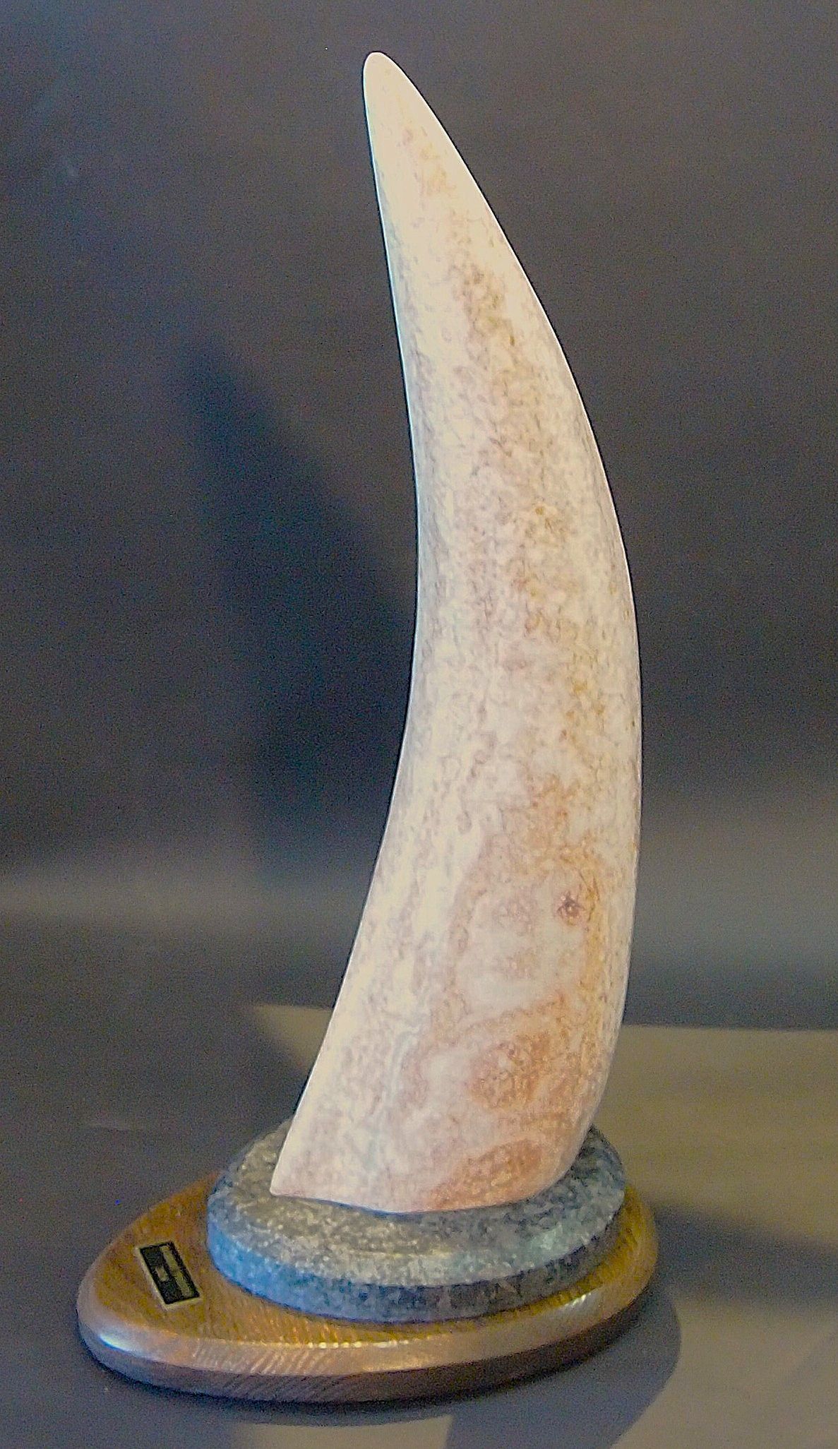 A small sculpture of a sailboat is sitting on a table.