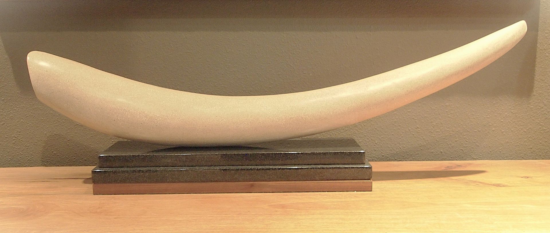 A large white horn is sitting on top of a wooden table.