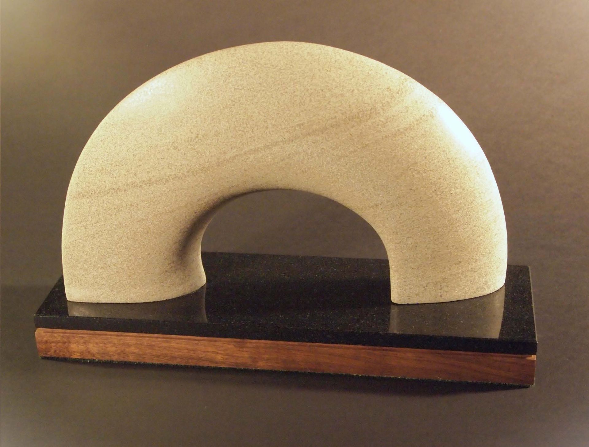 A sculpture of an arch on a wooden base