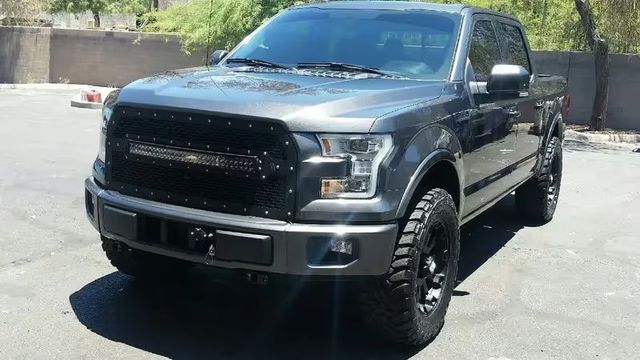 Black pickup truck parked outdoors in bright sunlight