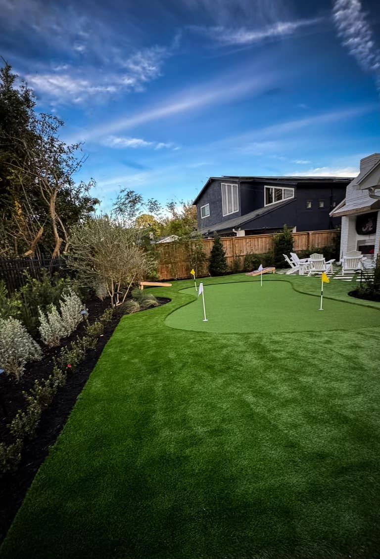 a lush green lawn surrounded by trees and bushes in a garden .
