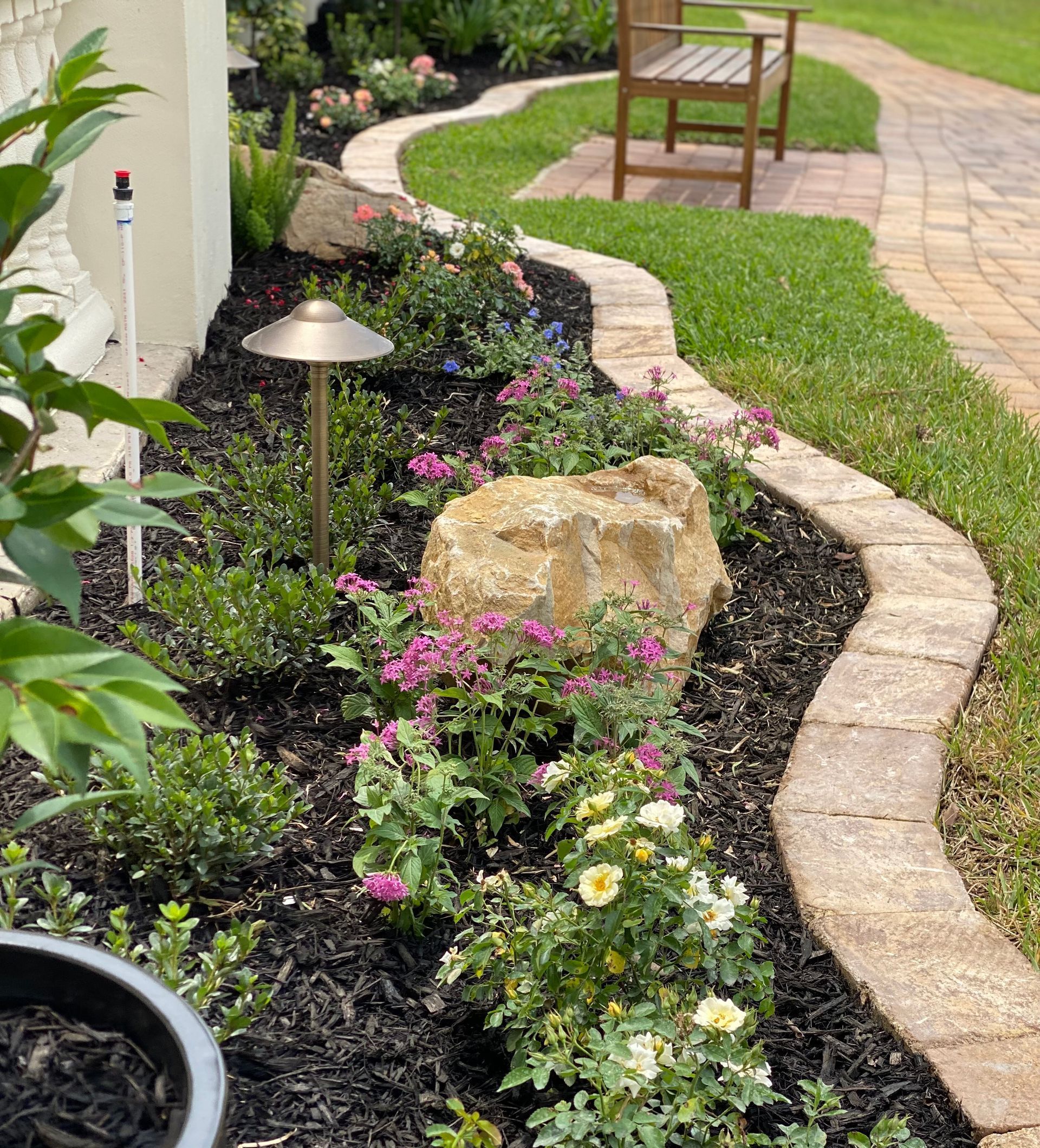 a patio with a grill , table and chairs and an umbrella .