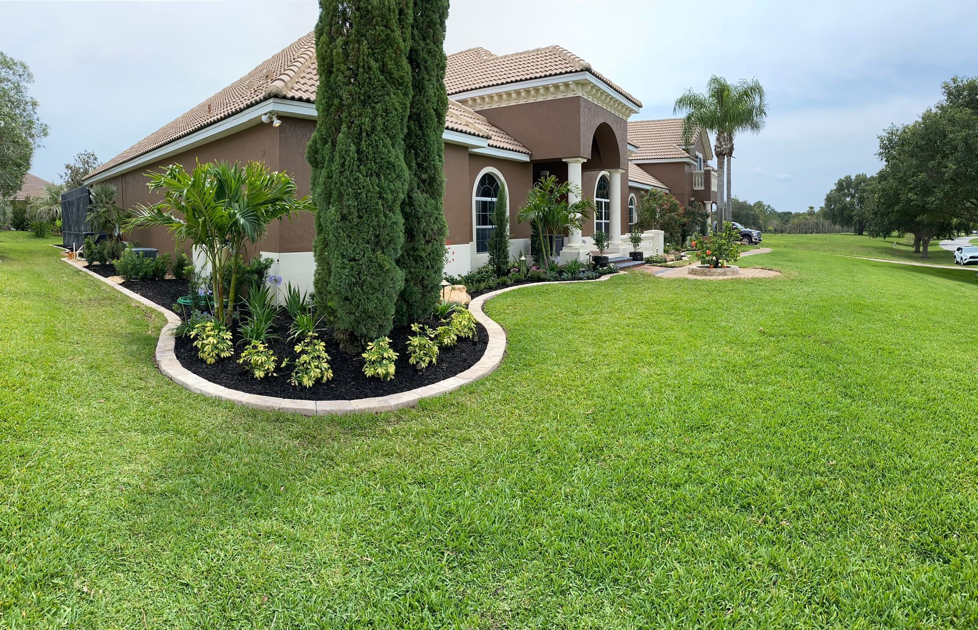 a lawn mower is cutting a lush green lawn in a backyard .