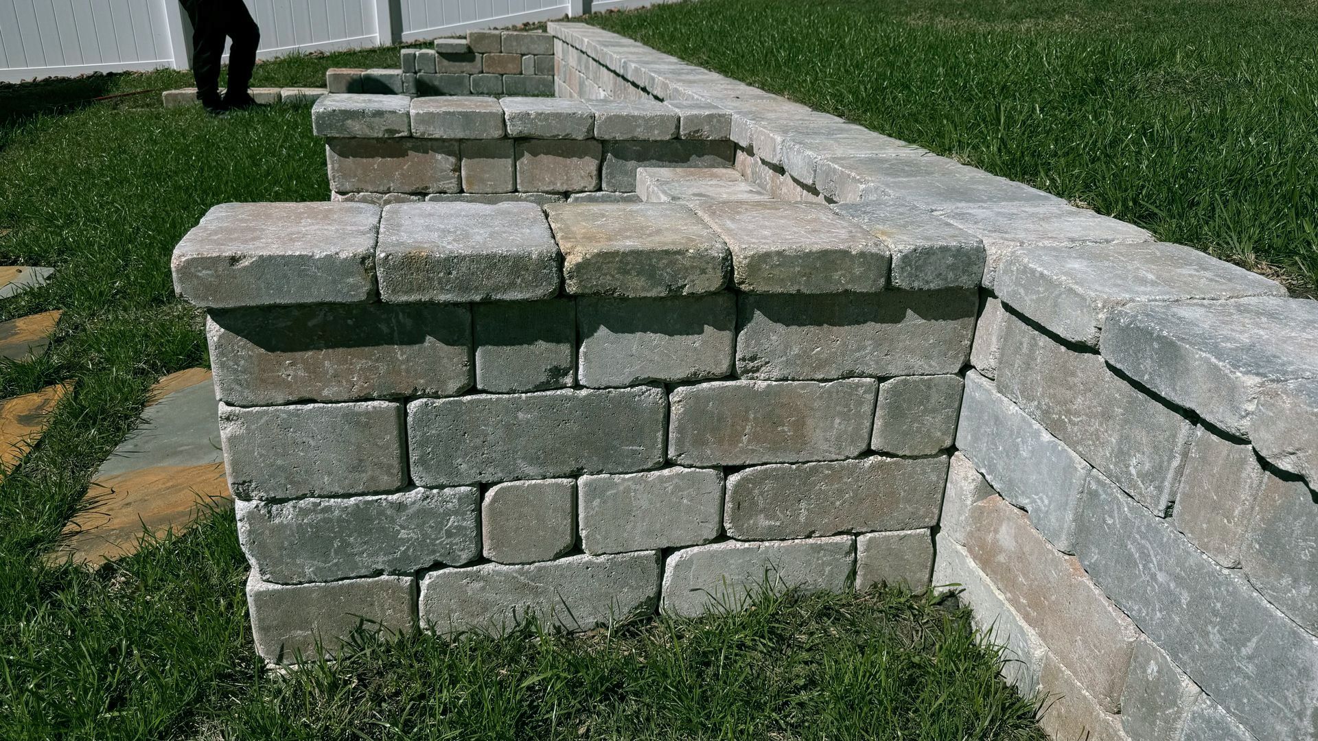 a stone wall surrounded by flowers in a garden .
