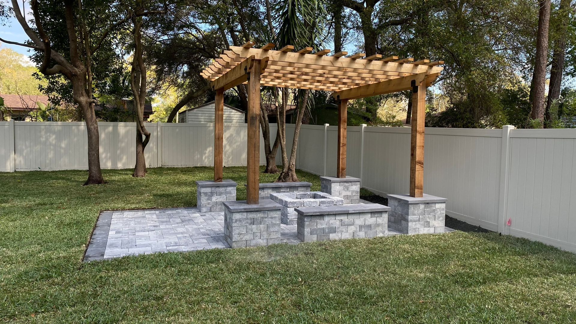 there is a swimming pool in the backyard of a house with a pergola over it .