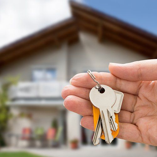 Person Hand Holding House Key — Cape Coral, FL — Ordonez Realty Person Hand Holding House Key — Cape Coral, FL — Ordonez Realty