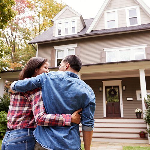 Couple Outside Their New House — Cape Coral, FL — Ordonez Realty