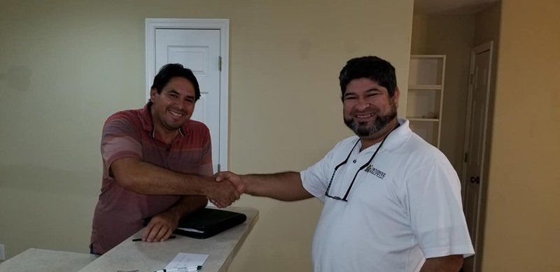 Two Smiling Men Shaking Hands Together — Cape Coral, FL — Ordonez Realty