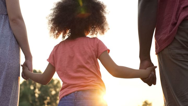 Family of three holding hands