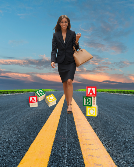 A woman in a suit is walking down a road with abc blocks on it