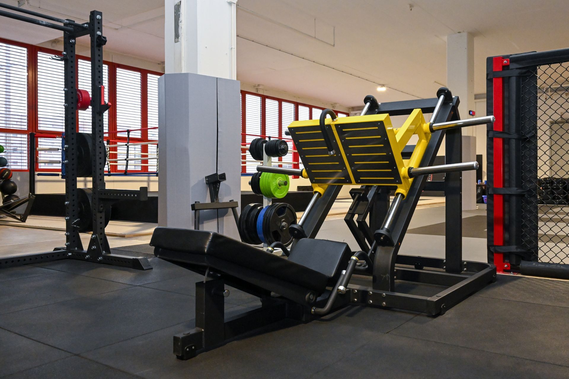 Ein Fitnessstudio mit vielen Trainingsgeräten und einer Bank.