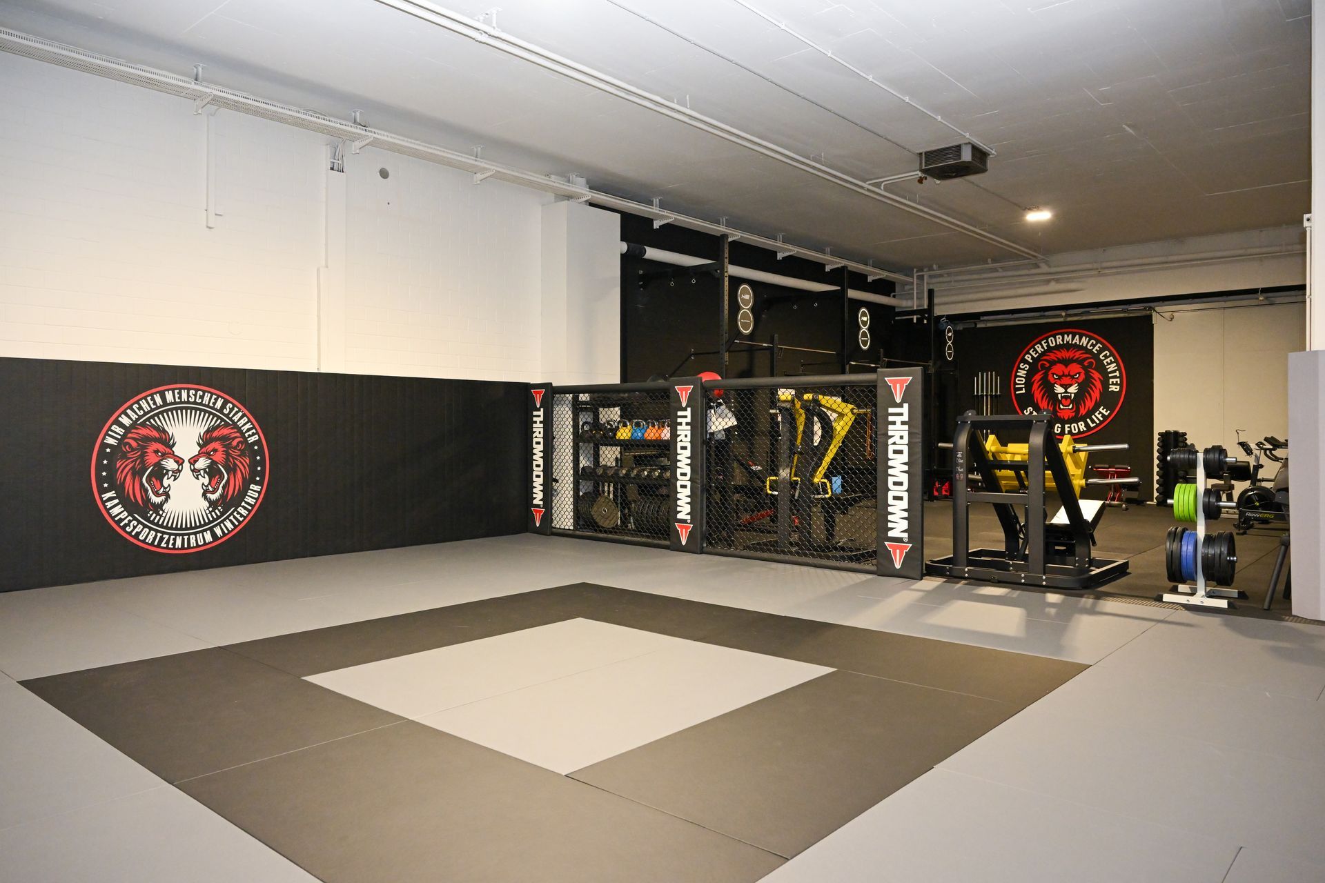 Ein Fitnessstudio mit vielen Trainingsgeräten und einer Bank.