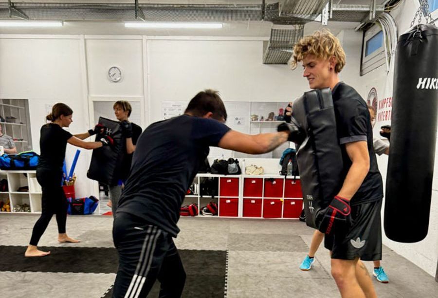 Eine Gruppe von Leuten boxt in einem Fitnessstudio.