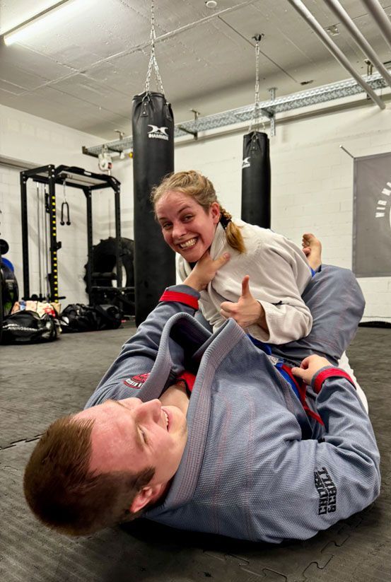 Ein Mann und eine Frau ringen in einem Fitnessstudio.