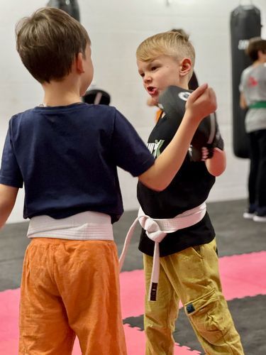 Zwei junge Jungen boxen in einem Fitnessstudio.