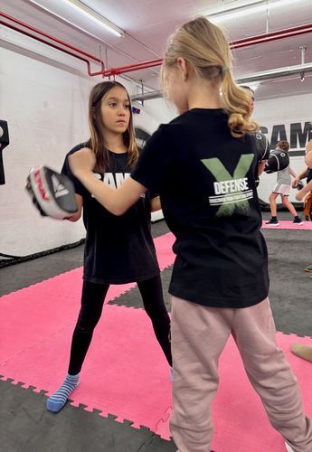 Zwei junge Mädchen boxen in einem Fitnessstudio.