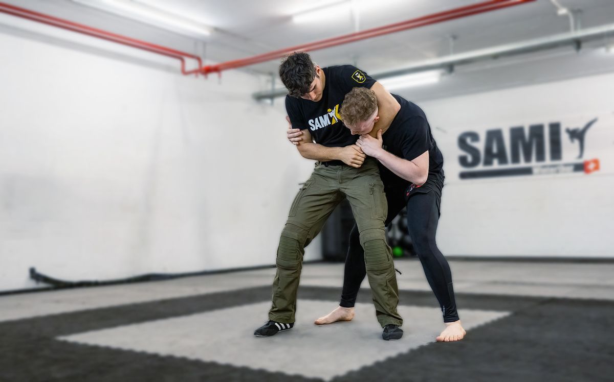 Zwei Männer üben in einem Fitnessstudio Kampfsport.