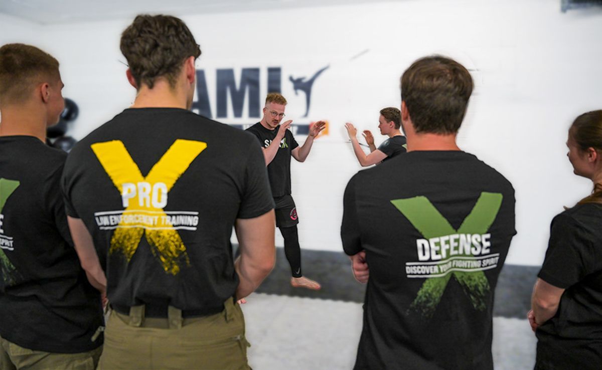 Eine Gruppe von Menschen, die schwarze T-Shirts mit der Aufschrift „Pro Defense“ tragen