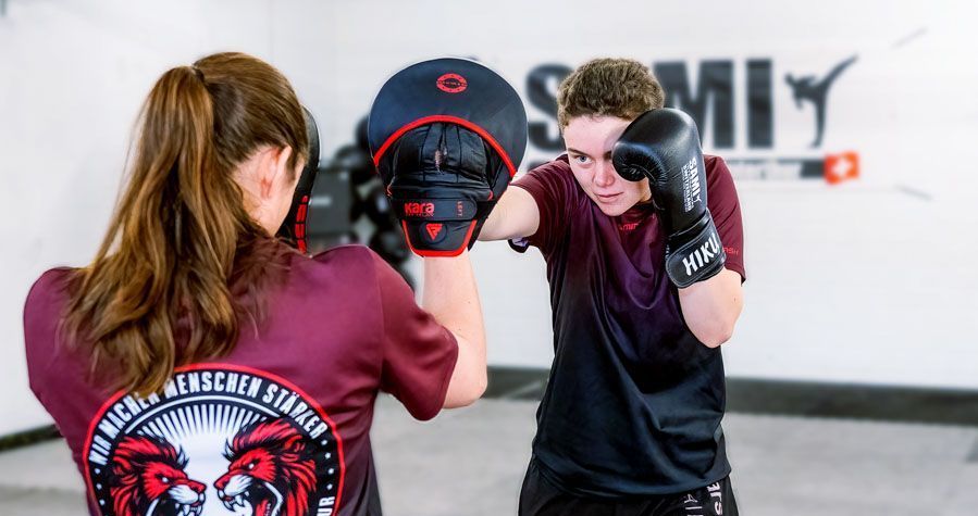 Ein Junge und ein Mädchen boxen in einem Fitnessstudio.