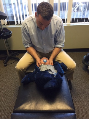 chiropractor assisting an infant