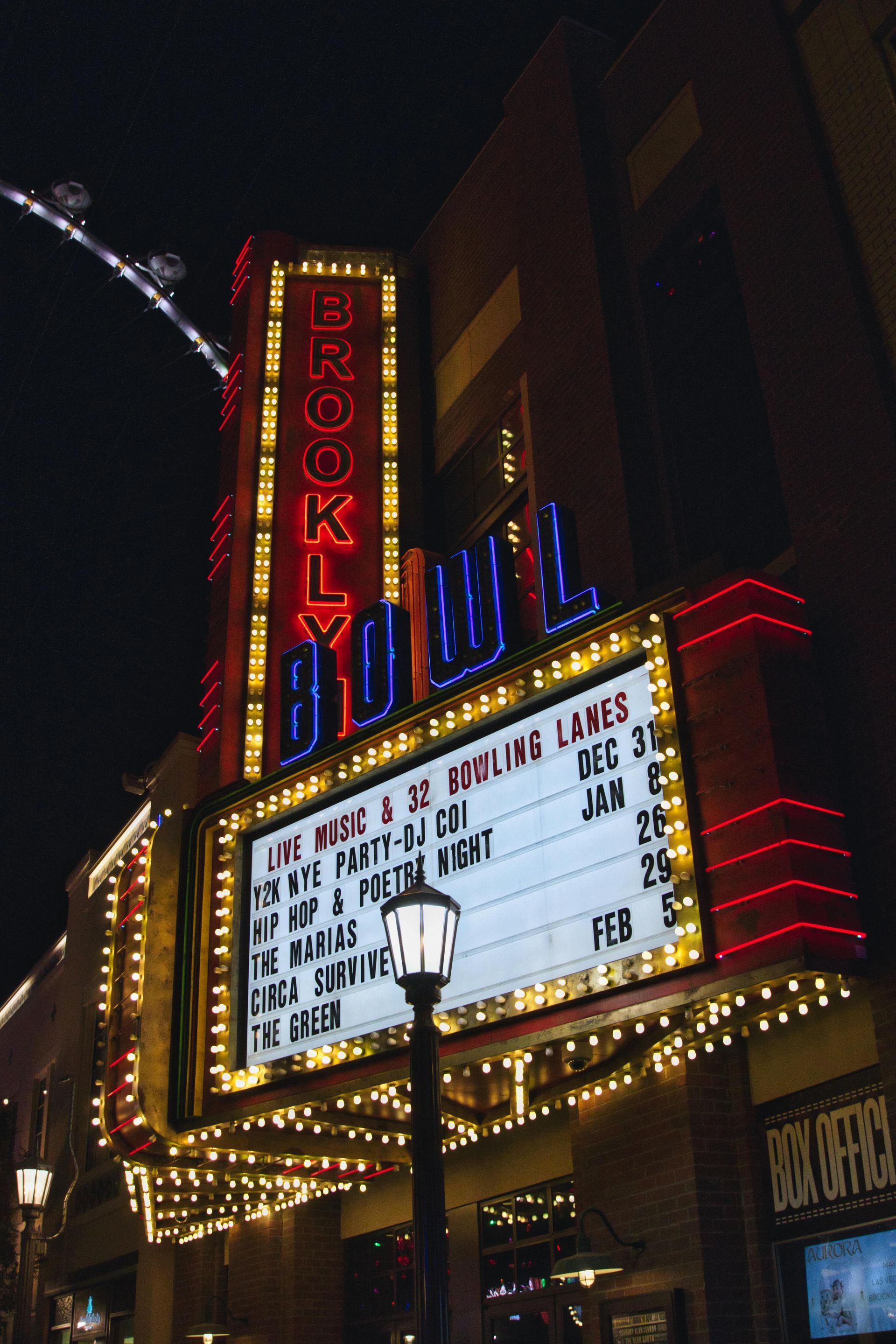 A night view of the Brooklyn Bowl neon marquee and sign lit up against the dark sky.