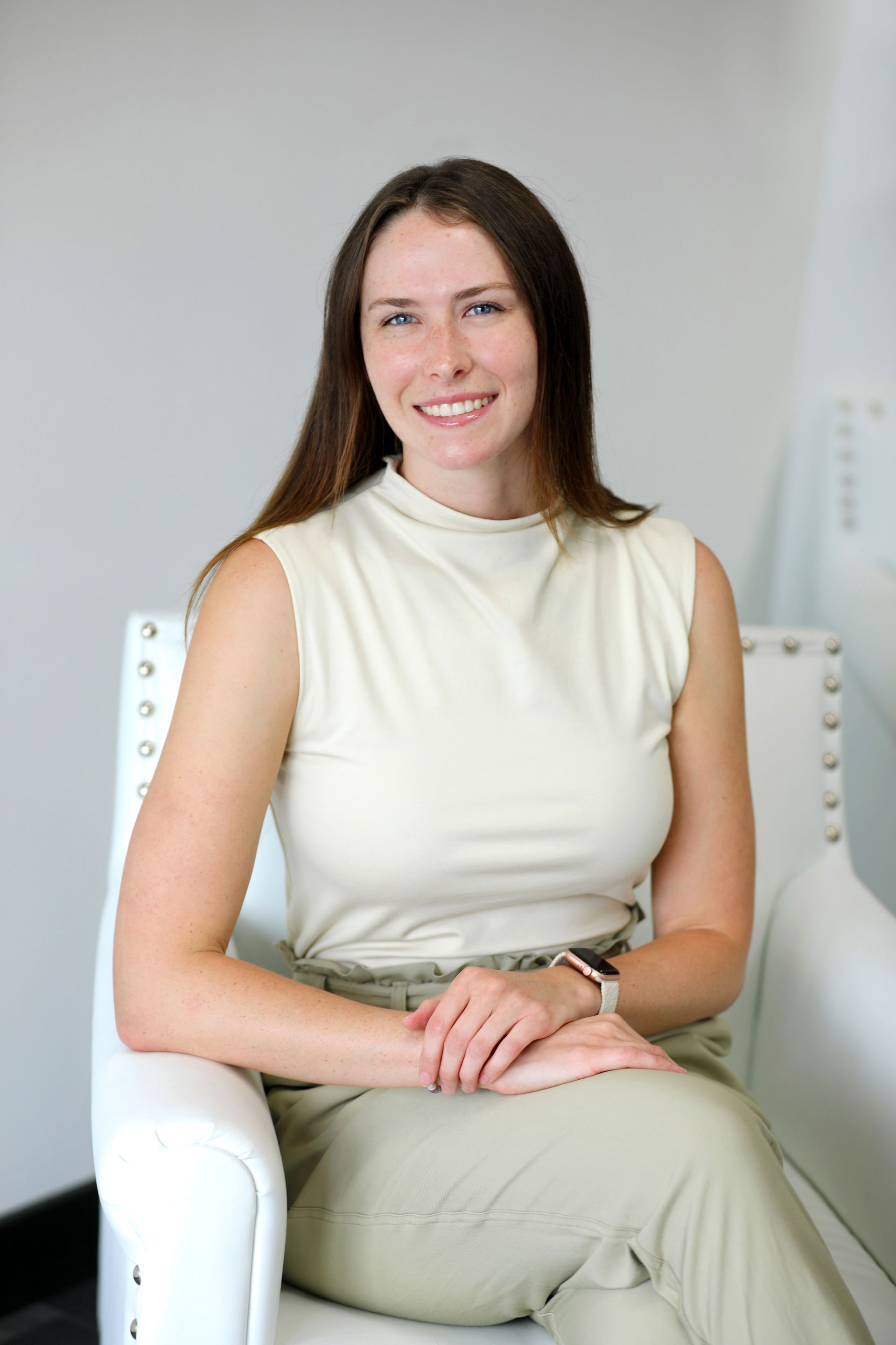 A woman in a red shirt is standing in a field of yellow flowers.