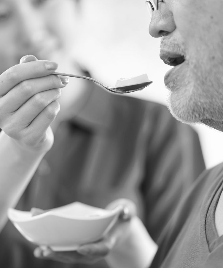 A man is eating from a bowl with a spoon