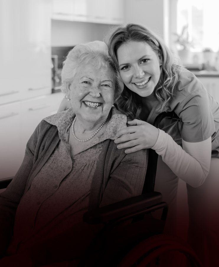 A woman is hugging an older woman in a wheelchair.