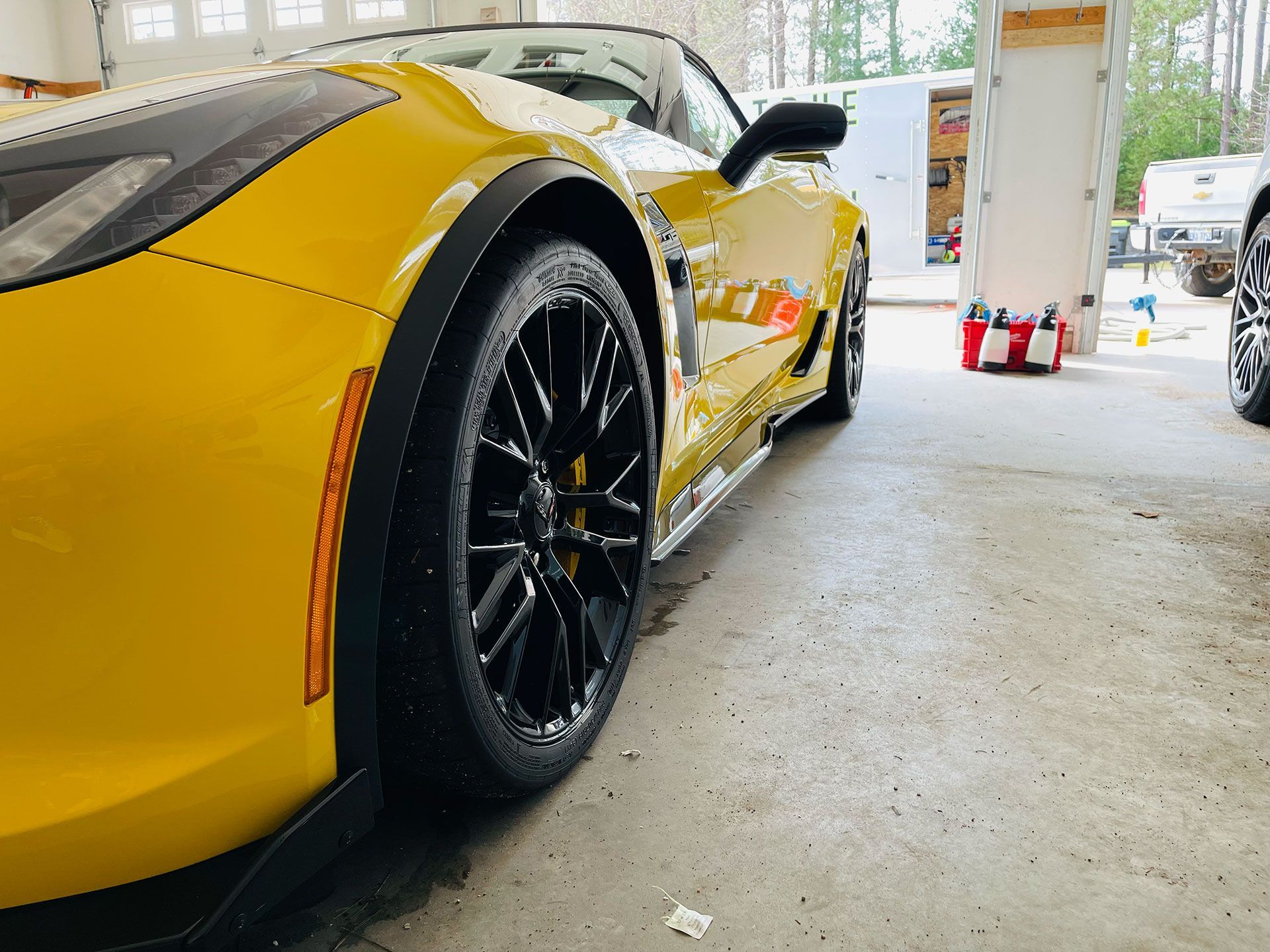 a modern yellow and black chevrolet corvette sports car in the process of being detailed