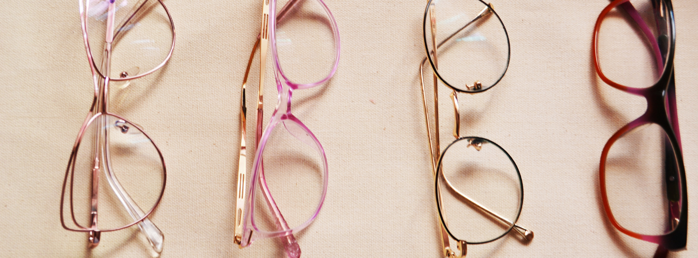 A man wearing glasses and a turtleneck is walking down the street.