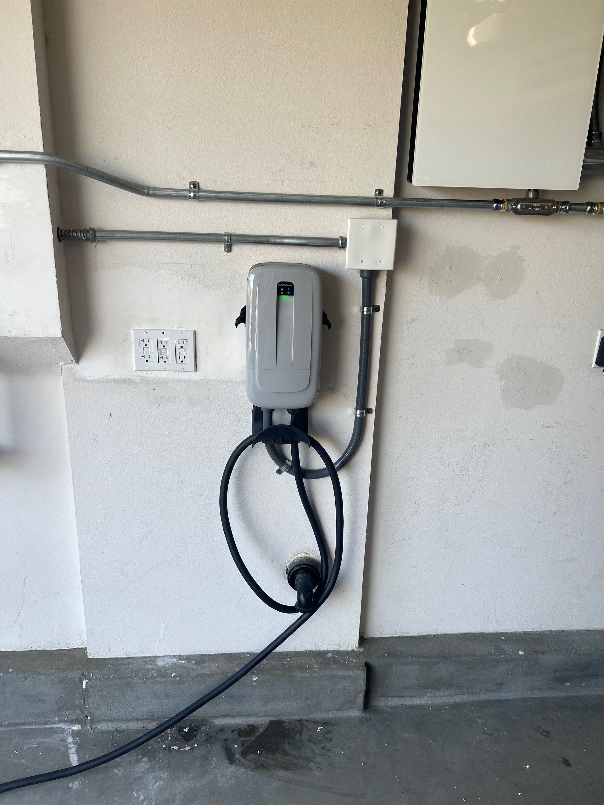 A charging station is attached to a wall in a garage