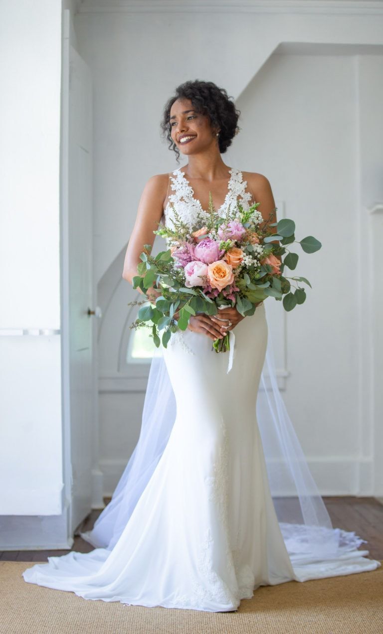 A woman in a wedding dress is holding a bouquet of flowers.