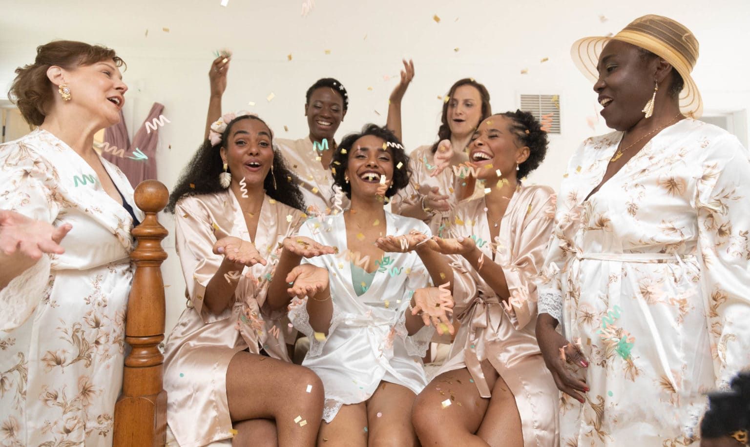 A bride and her bridesmaids are throwing confetti in the air.