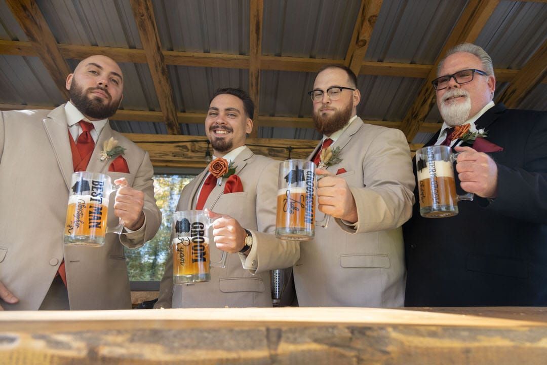 A group of men are standing next to each other holding beer mugs.