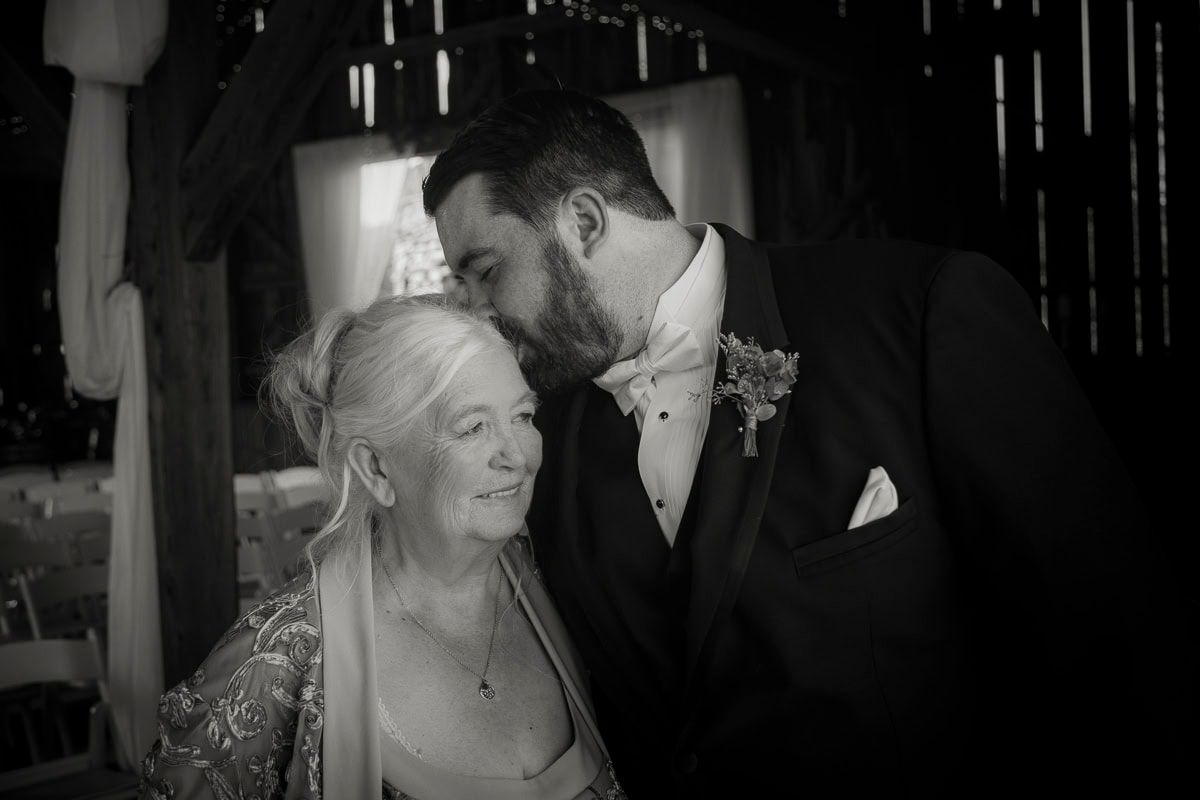 A bride and groom are kissing in a black and white photo.