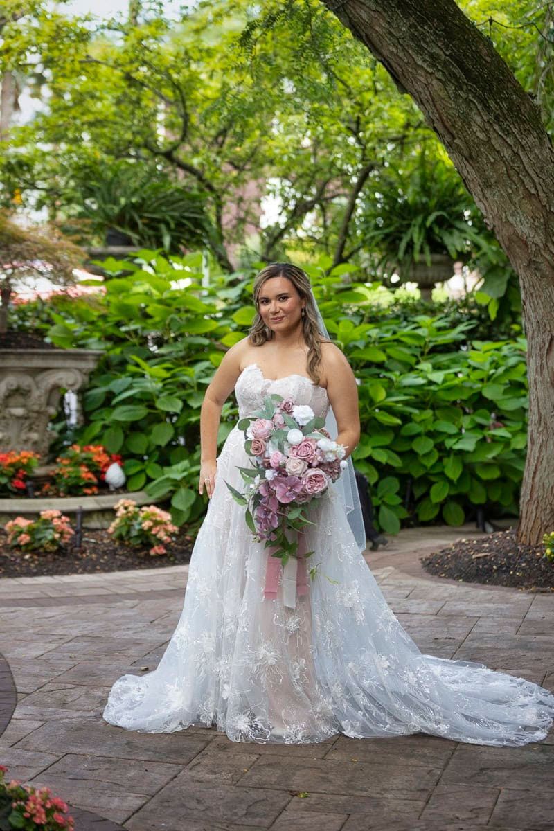 The bride is wearing a white wedding dress and holding a bouquet of flowers.