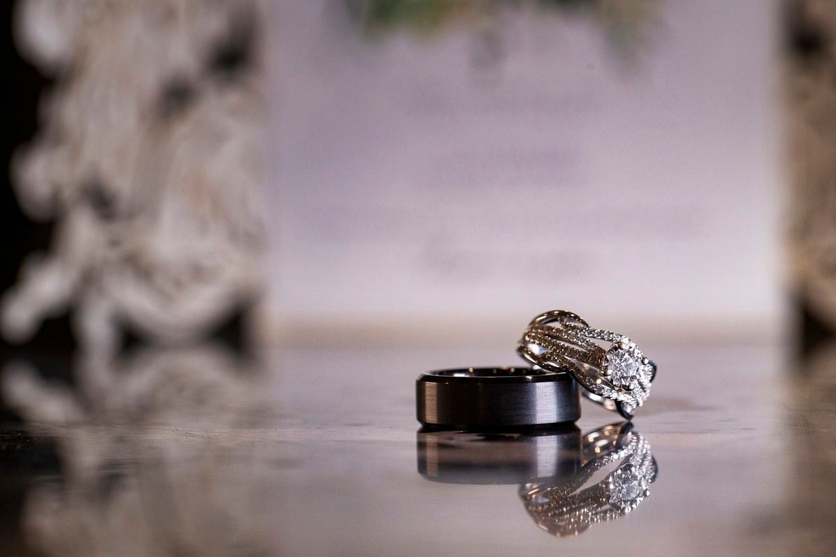 A close up of a bride and groom 's wedding rings on a table.