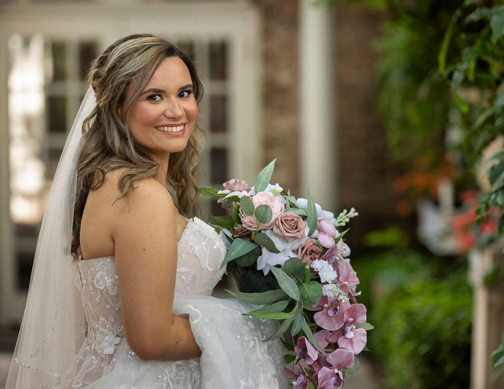 A bride in a wedding dress is holding a bouquet of flowers.