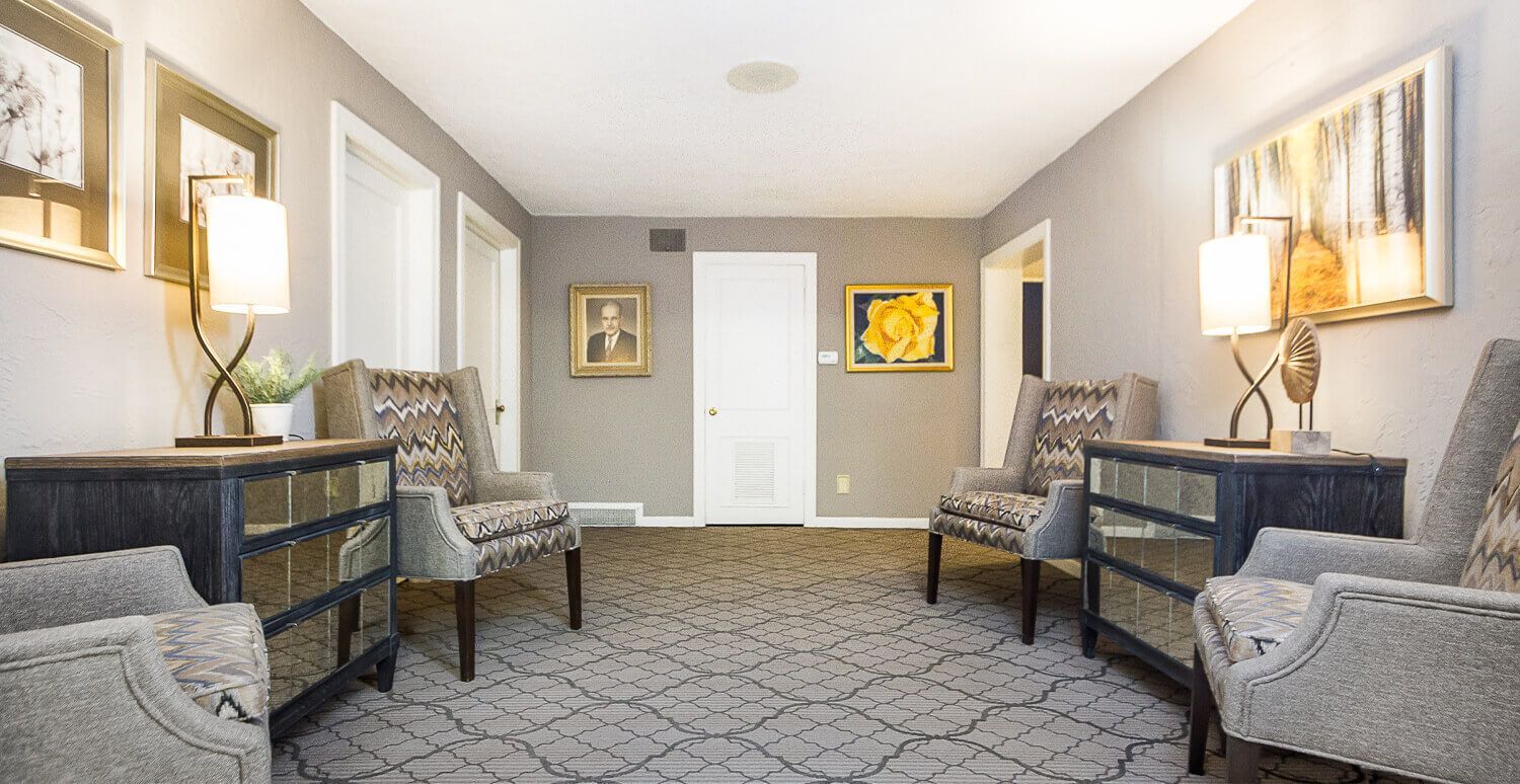 A long hallway with chairs , tables and lamps.