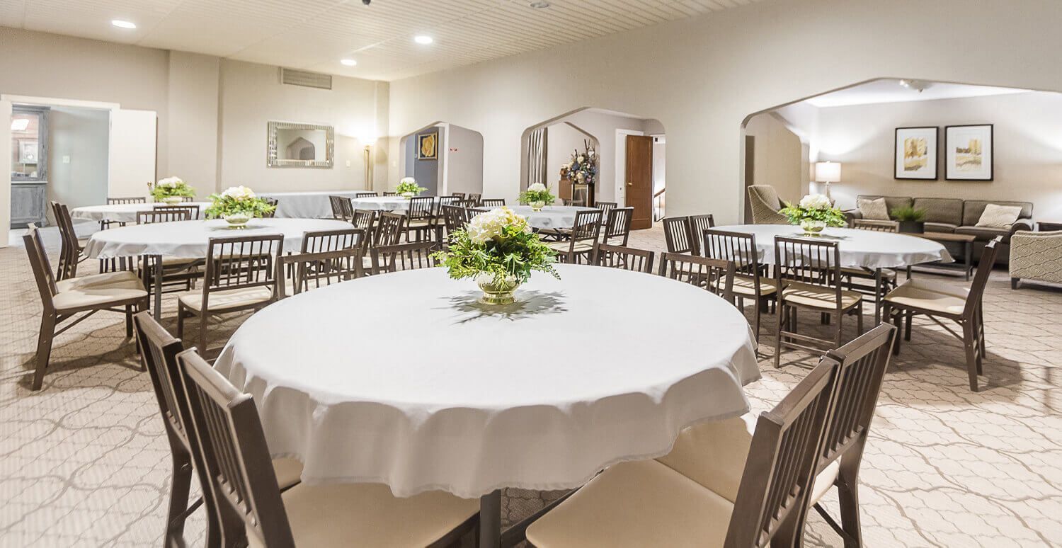 A large room with tables and chairs set up for a party.