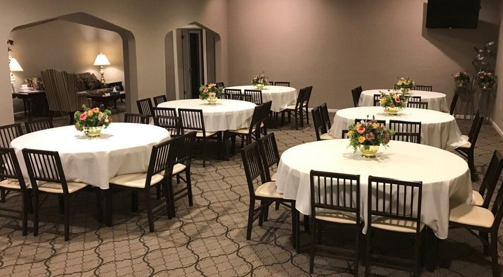 A room with tables and chairs set up for a wedding reception.
