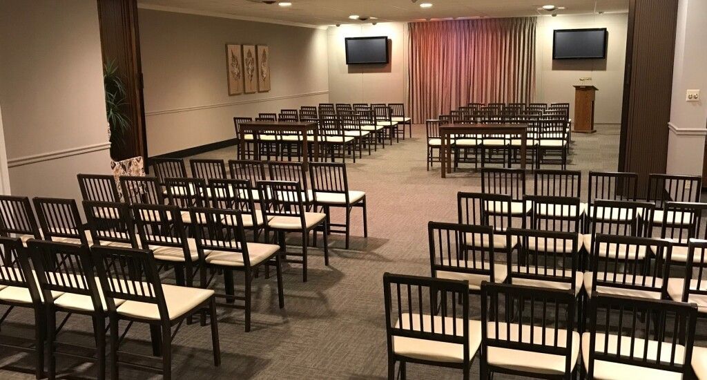 A large room filled with rows of chairs and a podium.
